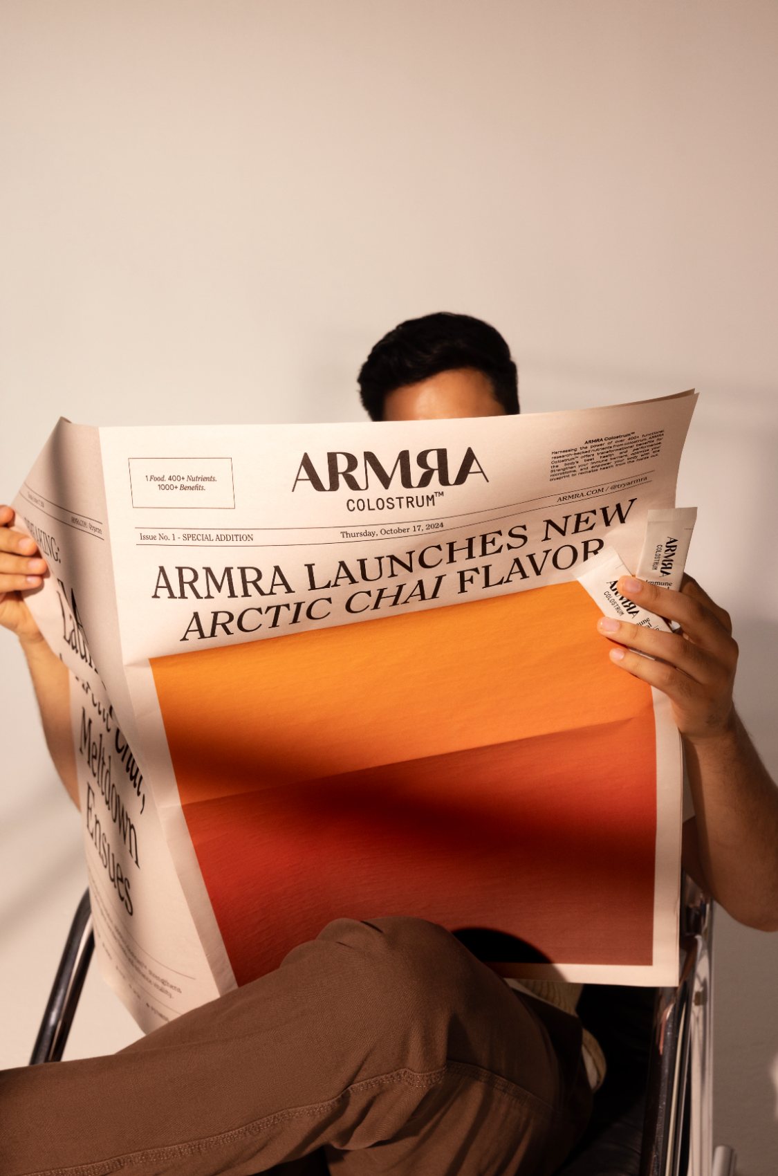 Person reading a newspaper headline announcing ARMRA's Arctic Chai flavor