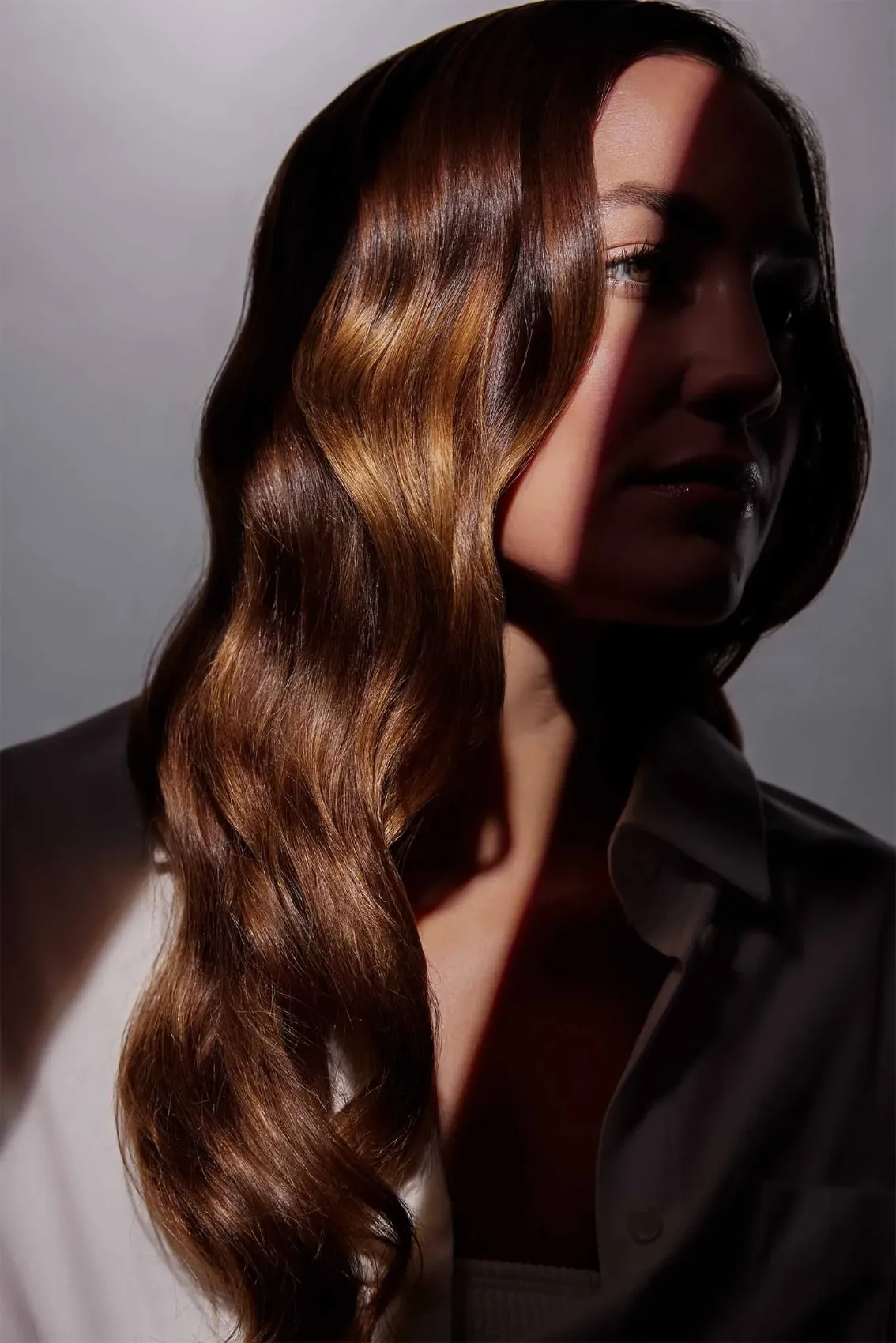 Model with long brunette waves in dramatic side light