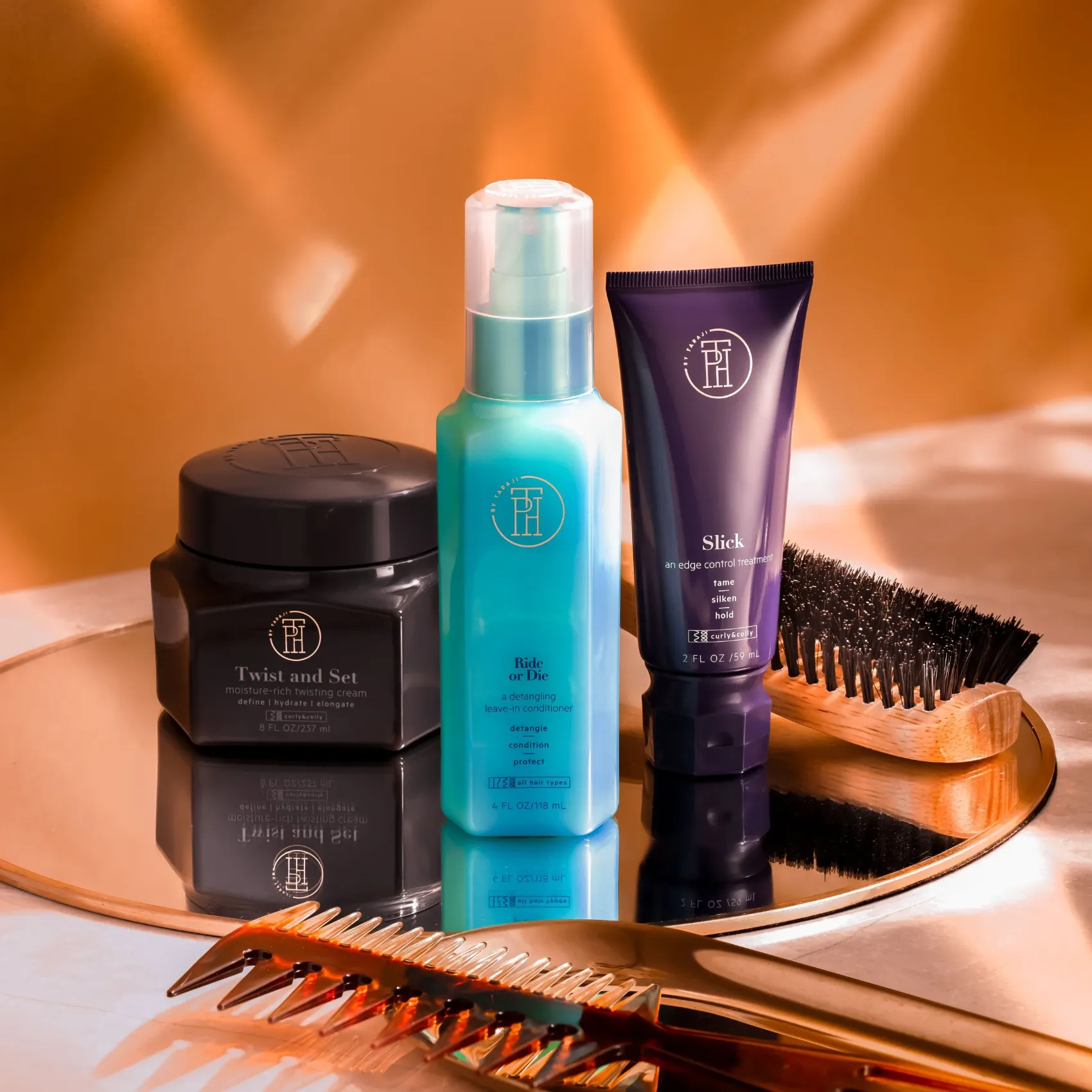 TPH hair products and a wooden comb on a mirrored tray