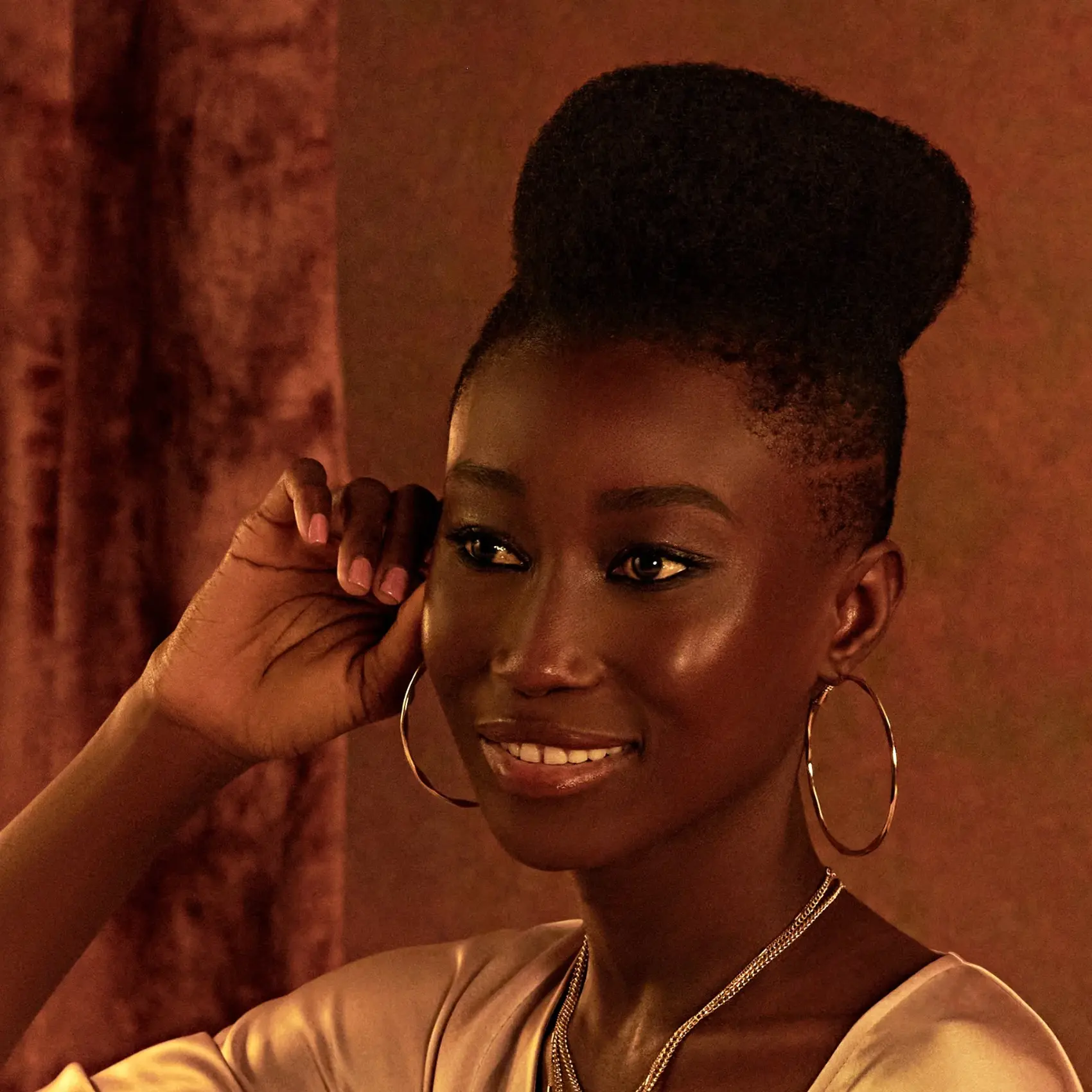 Model with a high bun and hoop earrings