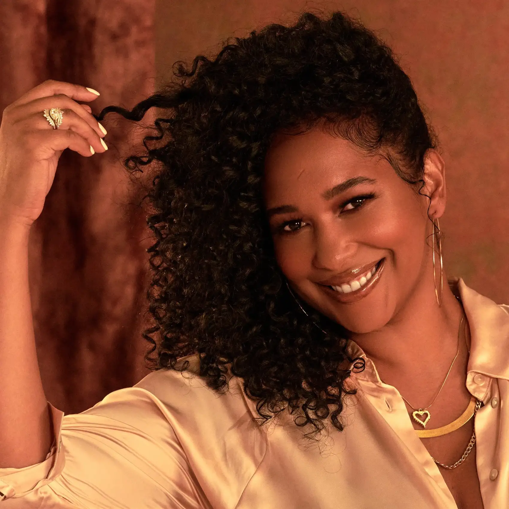Smiling model twisting a curl between her fingers