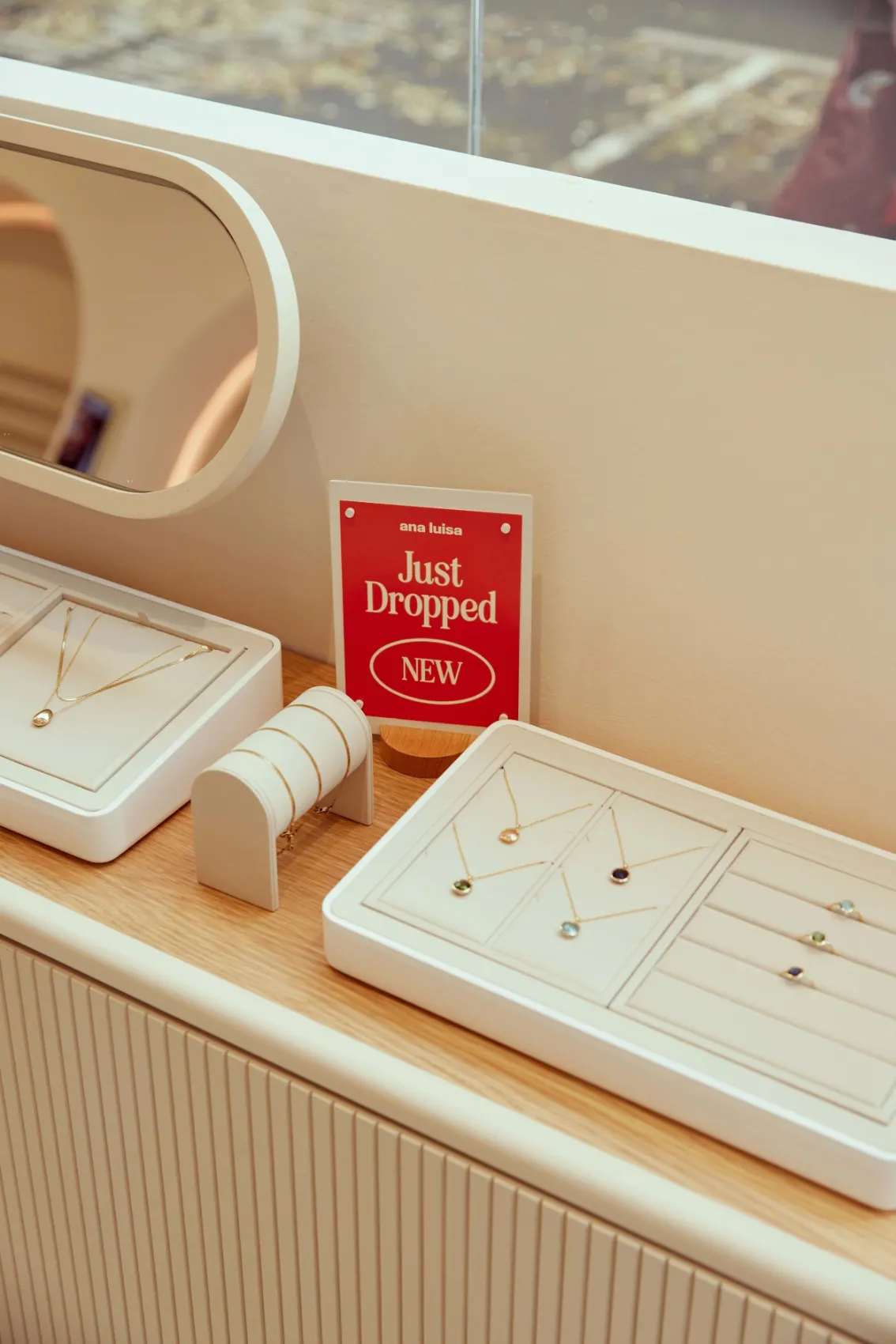 Necklace trays beside a “Just Dropped” sign