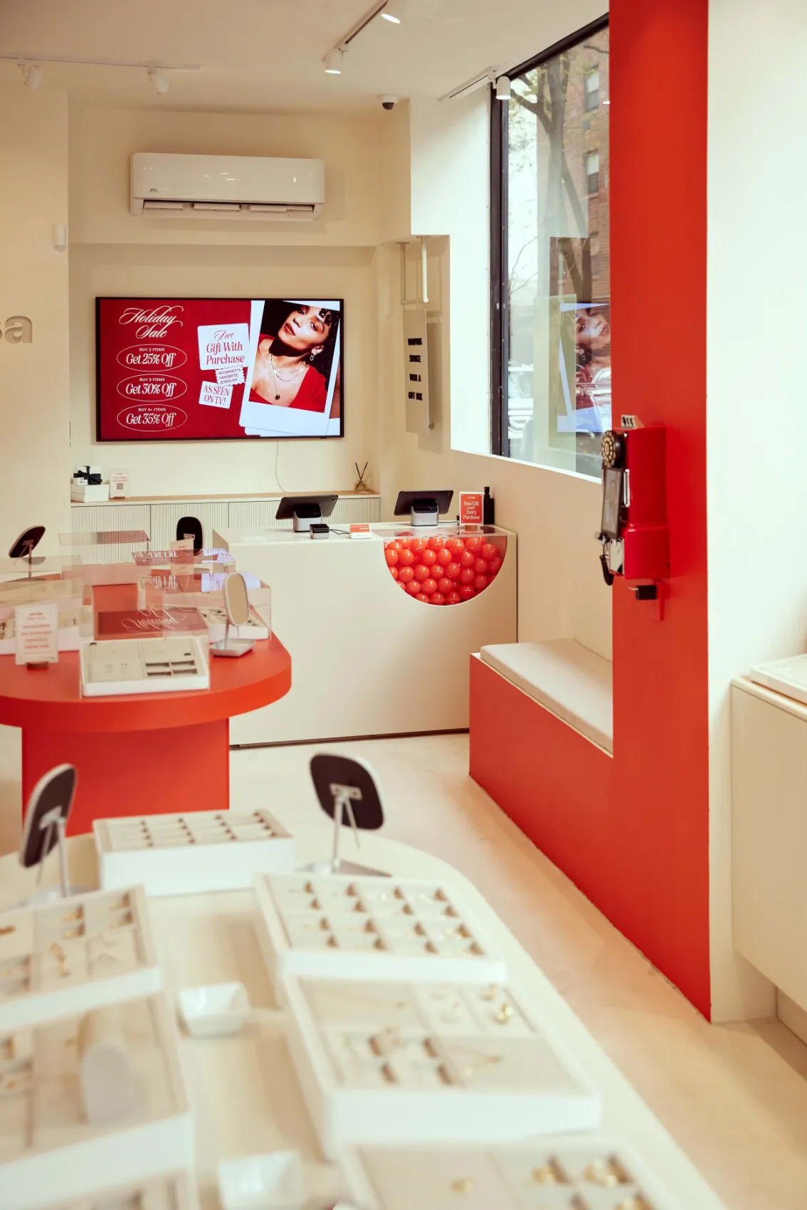 Store interior with a red column, display tables and a screen