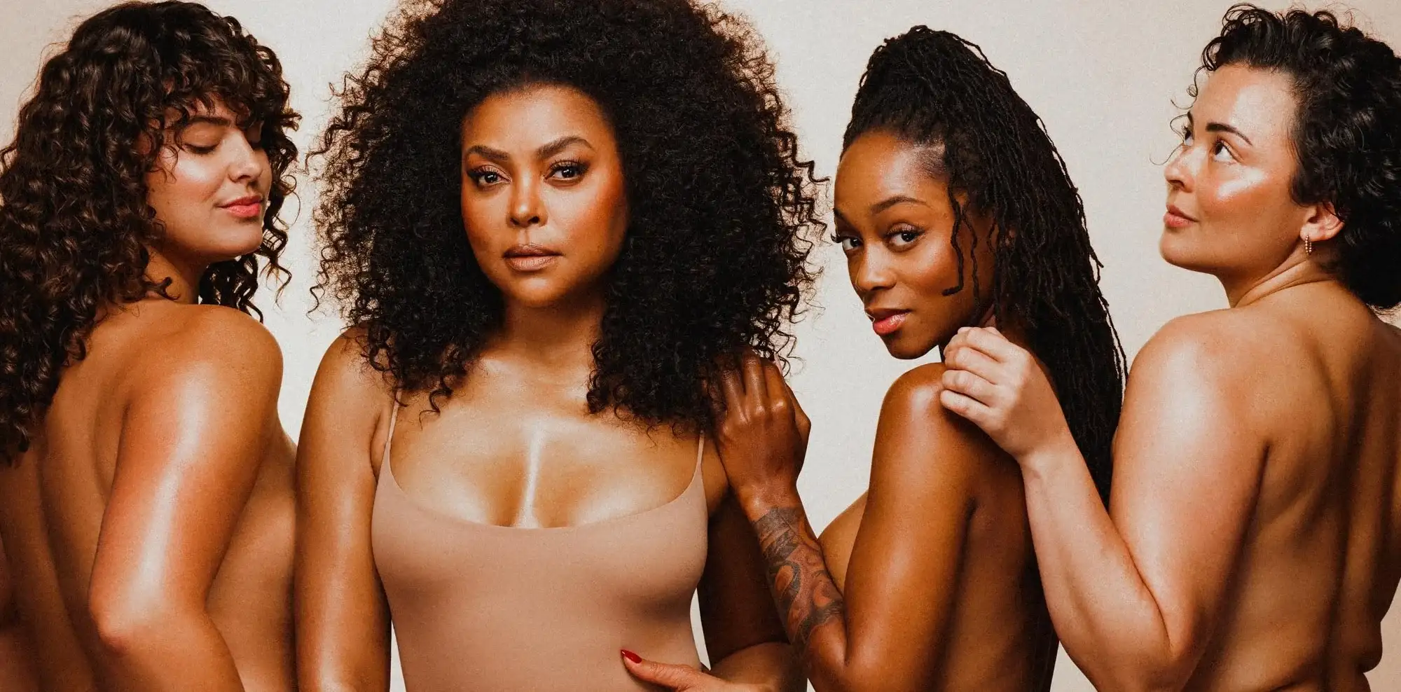 Four models posed together against a pale backdrop