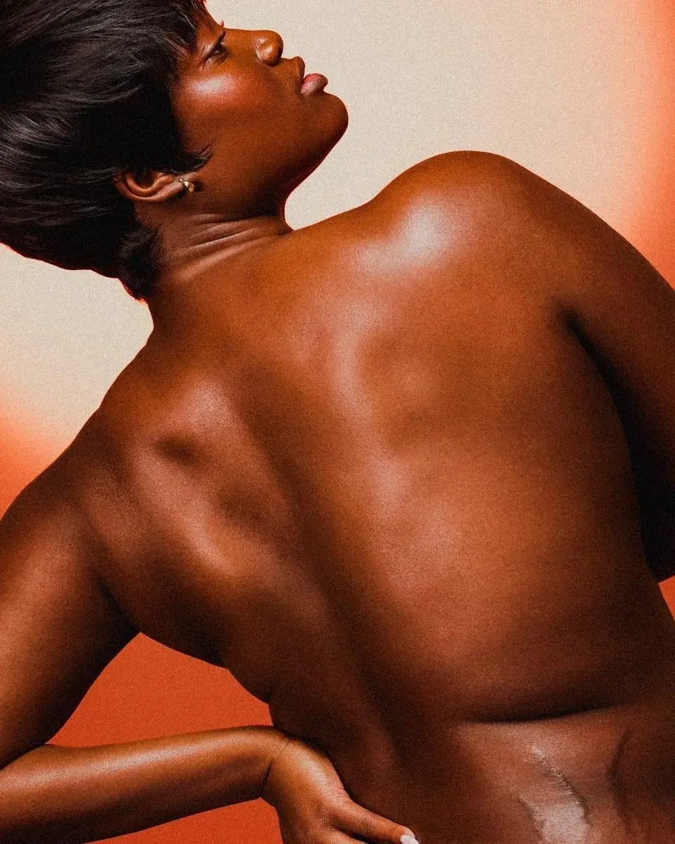Model’s bare back turned to an orange backdrop