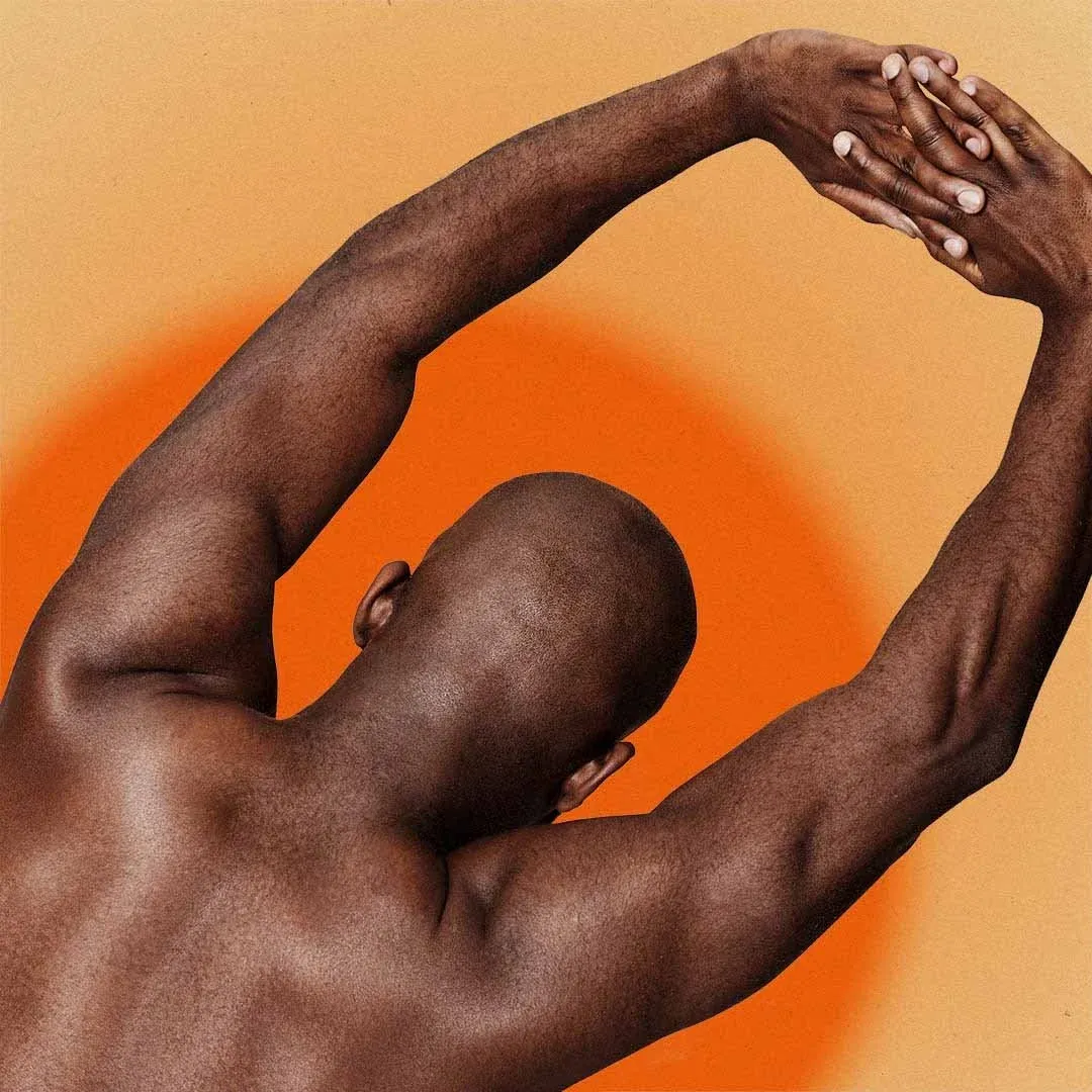 Man stretching with arms overhead against an orange glow