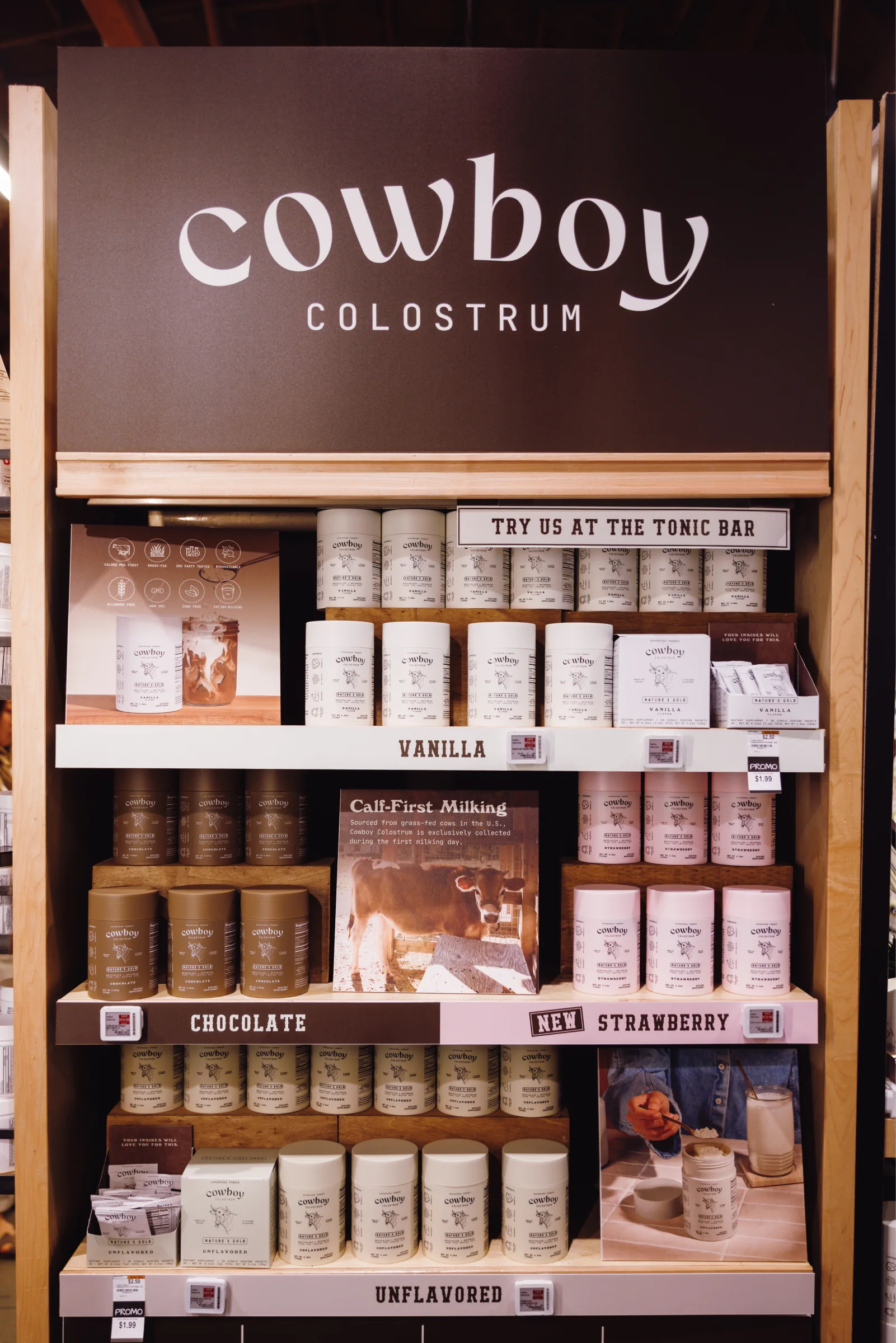 Close-up of the end cap: Vanilla, Chocolate, New Strawberry and Unflavored shelves with the Calf-First Milking card