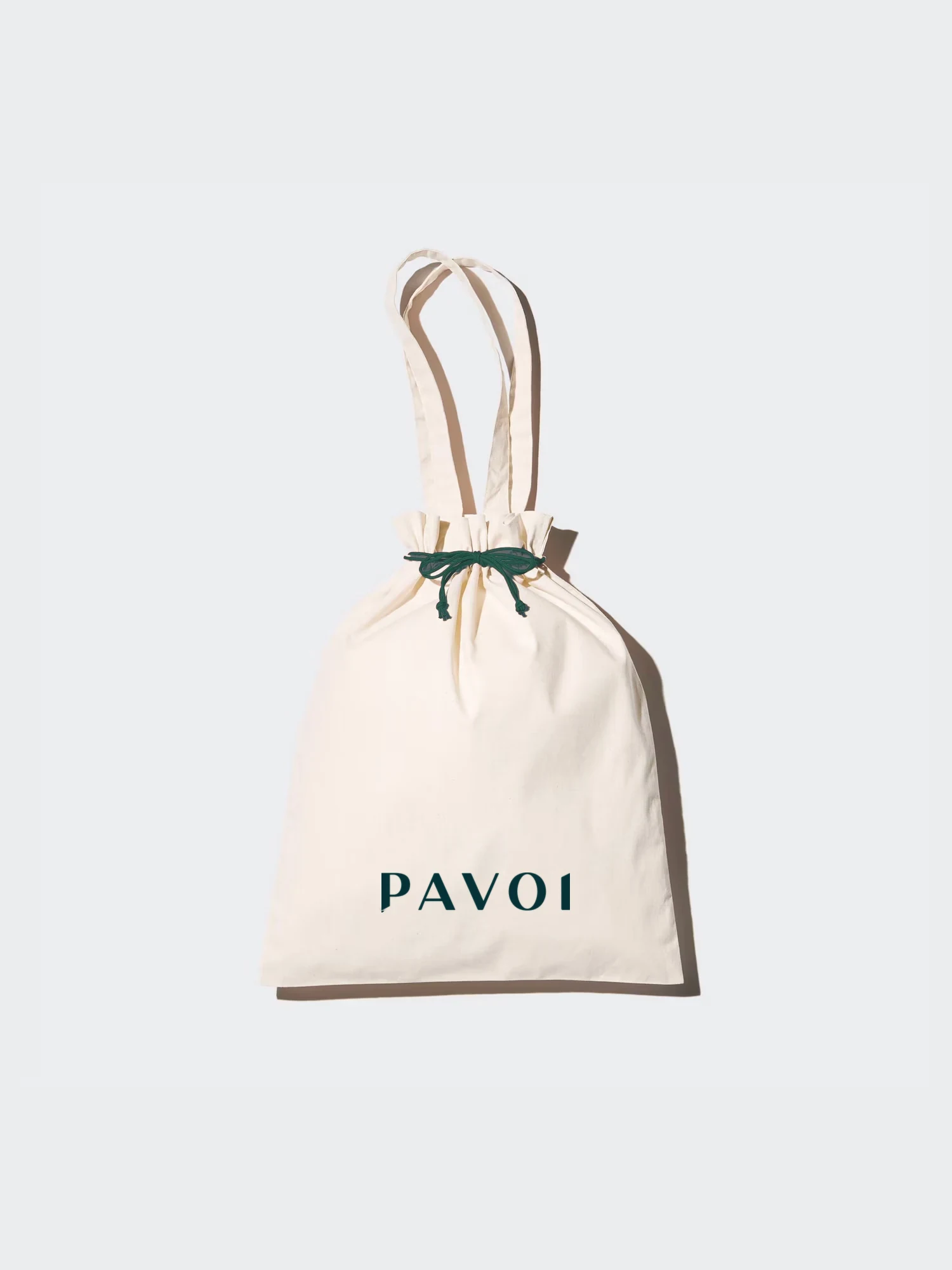 Cream drawstring PAVOI pouch with a forest-green ribbon